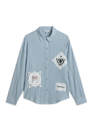 Lichtblauw button-up shirt van gestructureerde stof. Heeft drie patches: een met een vlinderontwerp, een met "CLUB NIGHT" en een met "Boutique de rose."