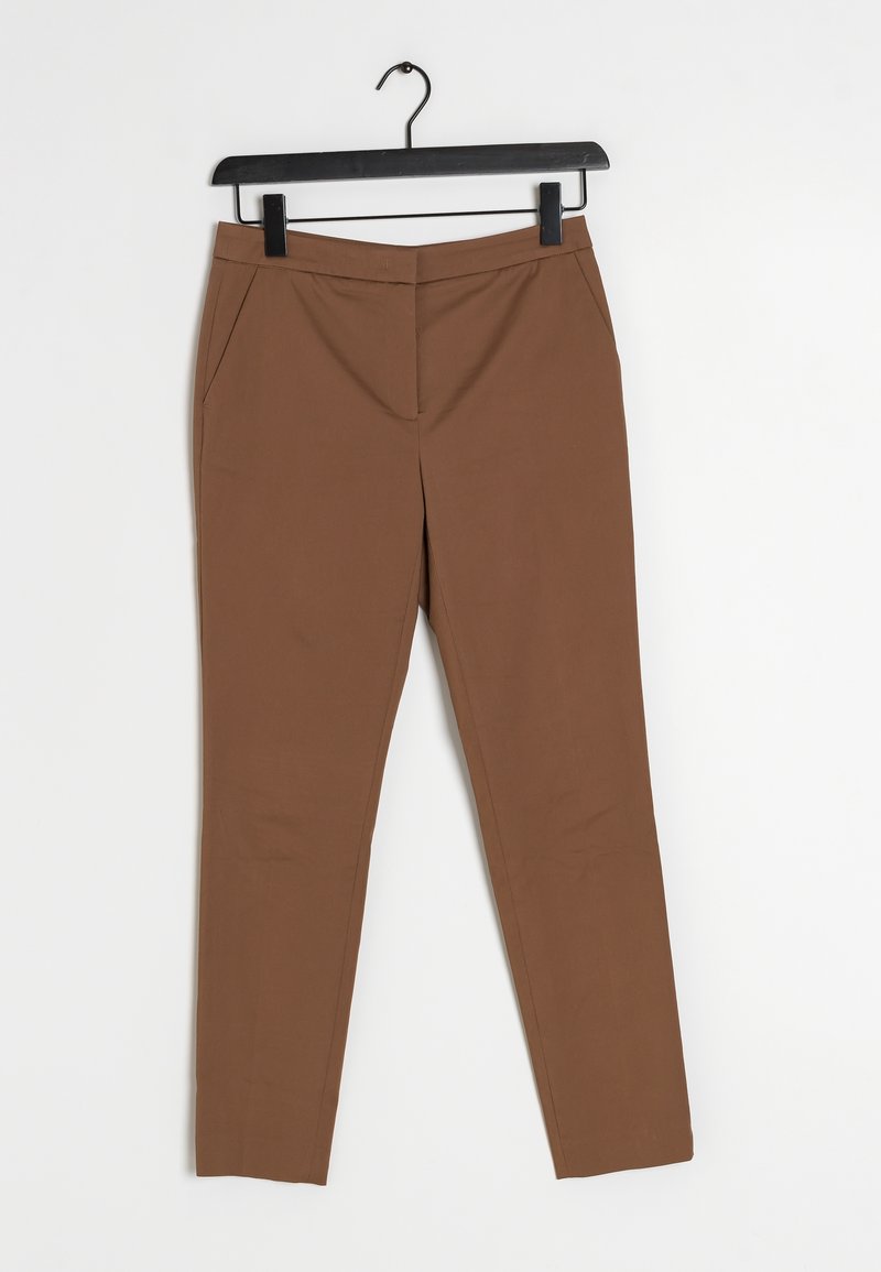 Pantalon marron coupe slim avec poches avant, suspendu sur un cintre noir, sur fond blanc uni.