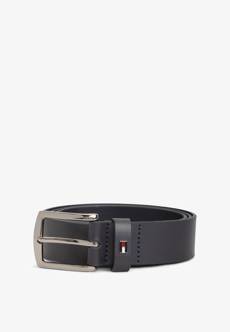 Ceinture en cuir noir roulée avec boucle rectangulaire argentée et petit logo rouge, blanc et noir sur la boucle de ceinture.