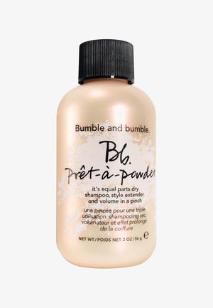 Bumble and bumble Prêt-à-Powder droogshampoo fles, zachtgoud met een zwarte geribbelde dop, heeft zwarte tekst en een etiket in het Engels en Frans.