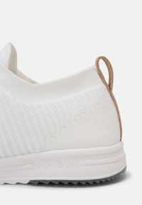 Talons de baskets en tissu tricoté blanc avec languette de tirage marron et semelle blanche embossée du logo "Marc O'Polo".