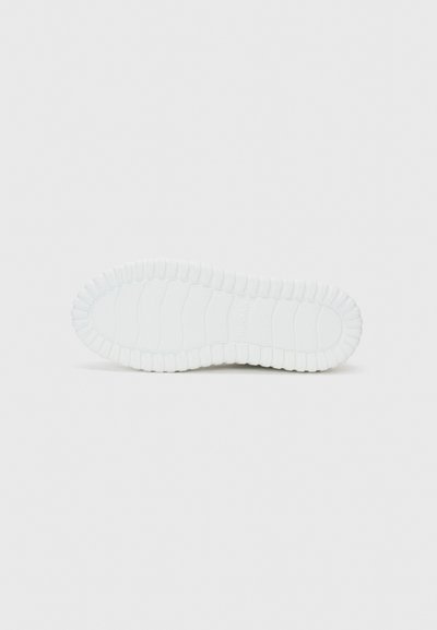 Semelle d'une sneaker : caoutchouc blanc avec une surface texturée, comportant des rainures horizontales et un bord arrondi. Design lisse et flexible.