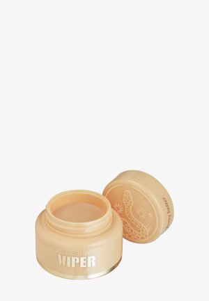 Petit pot beige de masque pour les lèvres Nabla Viper avec couvercle ouvert présentant un design en relief de serpent et d'étoile, l'étiquette indique un parfum beurre de miel.