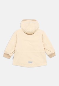 Ελαφρύ μπεζ αδιάβροχο μπουφάν με κουκούλα, ριμπ μανσέτες και ίσια γραμμή. Διαθέτει υφασμάτινη ετικέτα στο πίσω μέρος κοντά στο τελείωμα.