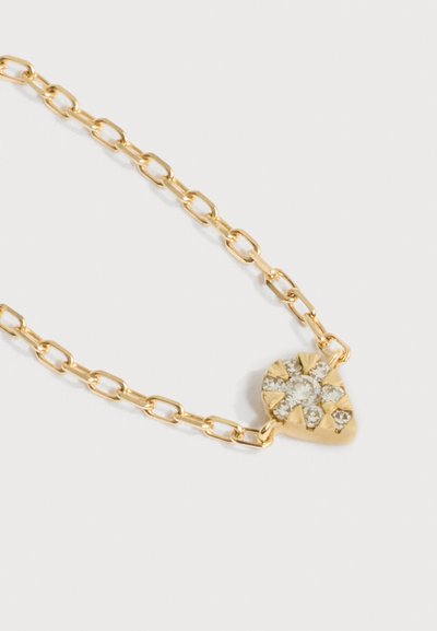 Χρυσό κολιέ με αλυσίδα και μικρό μενταγιόν σε σχήμα καρδιάς, στολισμένο με αρκετές λαμπερές διαυγείς πολύτιμες πέτρες.