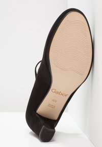 Zapato de tacón alto de ante negro con una suela texturizada, con una etiqueta de Gabor y marcado de tamaño 41/2. Fabricado en Portugal.