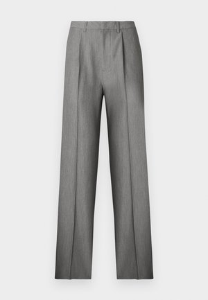 Pantalon gris sur mesure avec un devant plissé, une coupe droite et une texture subtile. Il présente une taille avec passants pour ceinture et aucune poche visible.