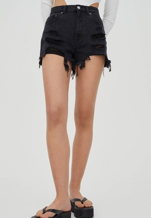 Pantalones cortos de mezclilla negra con detalles desgastados y dobladillos deshilachados. Diseño de cintura alta con estilo de cinco bolsillos y cierre de botón.