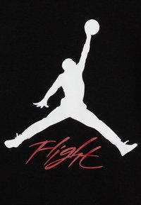 Biała sylwetka skaczącej postaci trzymającej piłkę do koszykówki, nad słowem „Flight” napisanym czerwonym pismem, na czarnym tle.