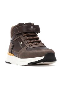 Zapatilla de deporte marrón de caña baja con cuello acolchado, parte superior de cuero sintético, cierre con cordones, correa de velcro y suela intermedia blanca. Suela de goma negra.