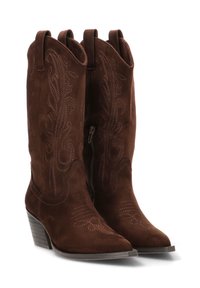 Un par de botas de vaquero de ante marrón con patrones florales bordados, puntas puntiagudas, cremallera lateral y tacones apilados, sobre un fondo blanco.