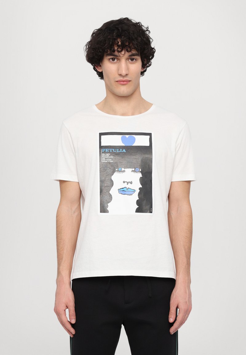 White cotton t-shirt featuring a graphic print with blue, black, and white colors, depicting a face with blue lips and eyes.