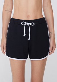 Schwarze Baumwollshorts mit einer weichen Textur, elastischem Bund und weißem Kordelzug. Mit weißen seitlichen Akzenten und einem klassischen sportlichen Schnitt.