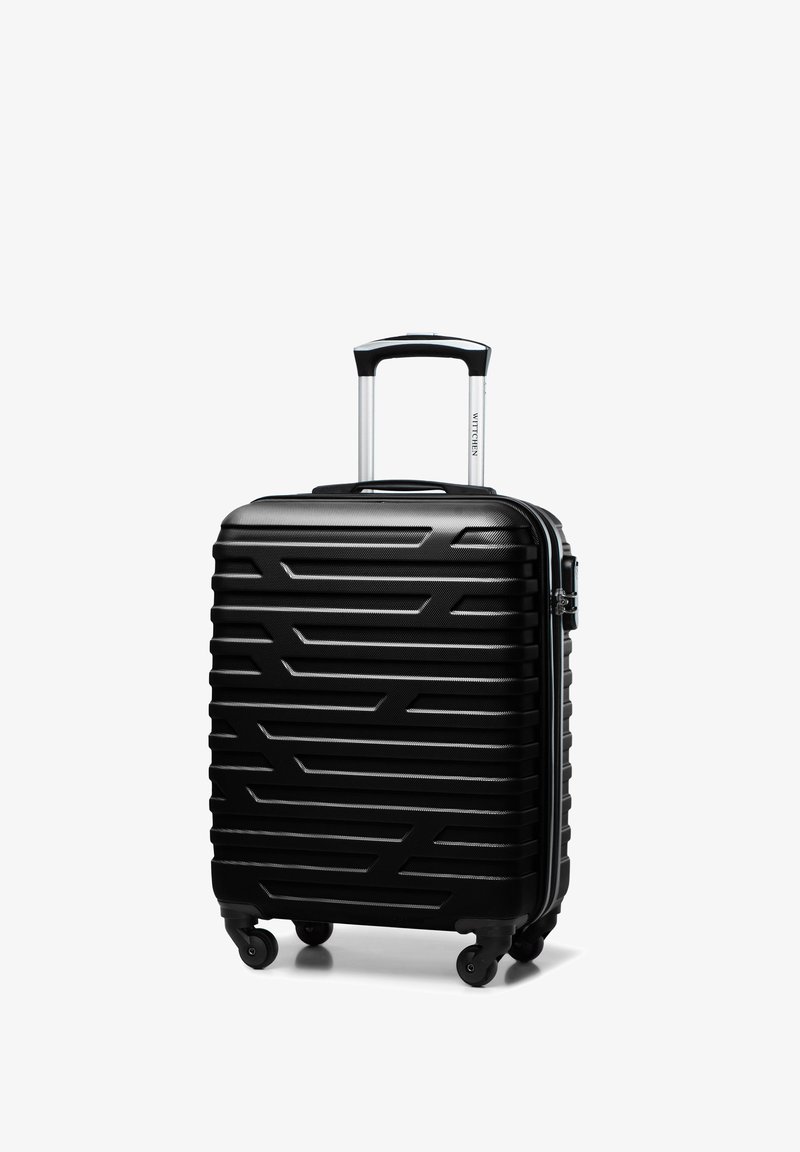 Zwarte hardshell koffer met een getextureerd zigzagpatroon, zilveren rits en uitschuifbare aluminium handgreep. Vier draaibare wielen voor mobiliteit.