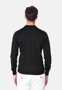 Maglione nero a maniche lunghe con collo rotondo, polsini e orlo a coste. Realizzato in un materiale a maglia liscia, presenta un design semplice senza motivi.