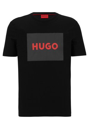 T-shirt en coton noir à manches courtes avec un grand rectangle gris et le mot "HUGO" en lettres rouges en gras sur le devant.