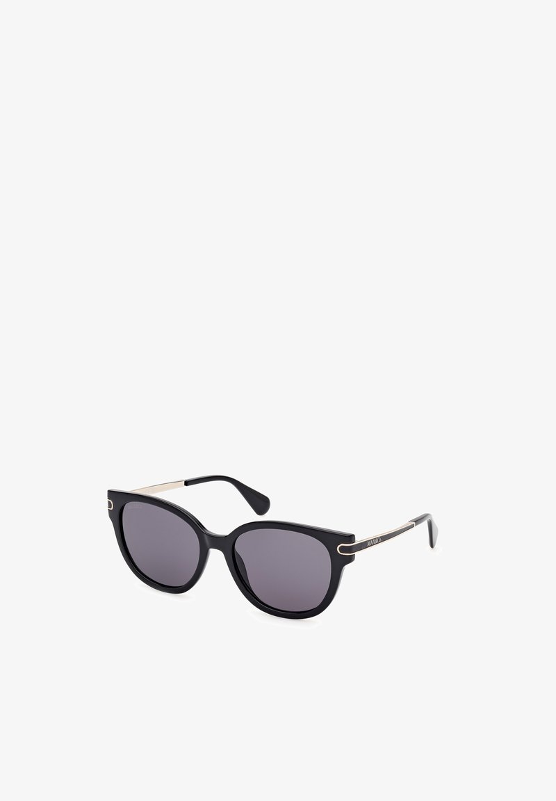 Gafas de sol de estilo cat-eye negro con lentes oscuros. Las monturas tienen un acabado mate y acentos dorados en las patillas, realzando el diseño.