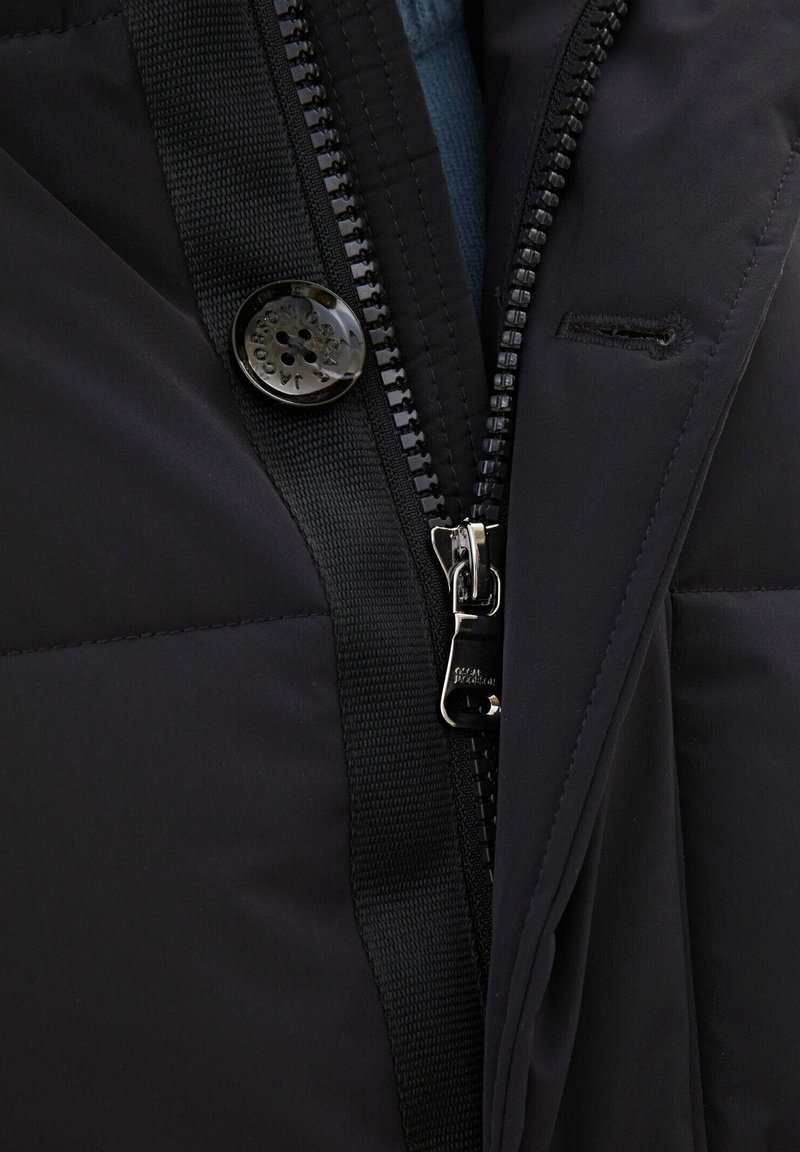 Czarna, ocieplana kurtka z suwakiem z przodu, teksturowanym materiałem i błyszczącym detalem na guzik, z widoczną niebieską podszewką wewnętrzną.