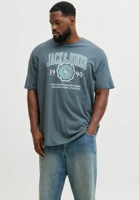 T-shirt in cotone grigio con scollatura rotonda, maniche corte e stampa grafica bianca con "JACK & JONES" e anno di fondazione 1990.