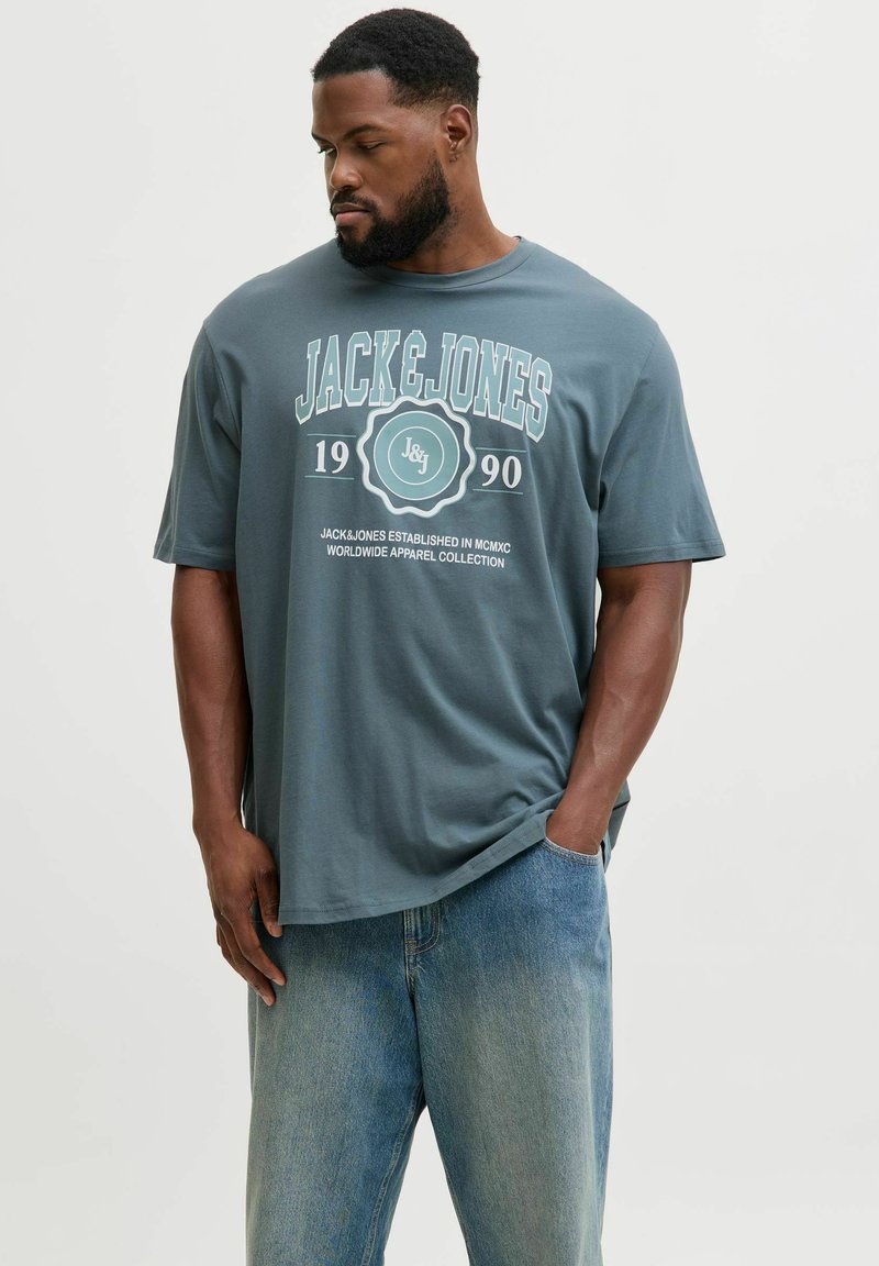 T-shirt in cotone grigio con scollatura rotonda, maniche corte e stampa grafica bianca con "JACK & JONES" e anno di fondazione 1990.