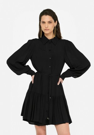 Black dress with long puff sleeves, button front, and a fitted waist. Features a tiered skirt and a waist tie for adjustment.