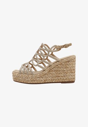 Sandalo beige con zeppa, suola piatta intrecciata, cinturini ad anello decorati con strass e fibbia regolabile alla caviglia.