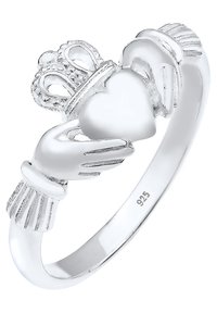 Ring av sterling silver som föreställer två händer som håller ett hjärta, krönt med en krona. Slät, polerad yta med detaljerad gravyr på händerna.