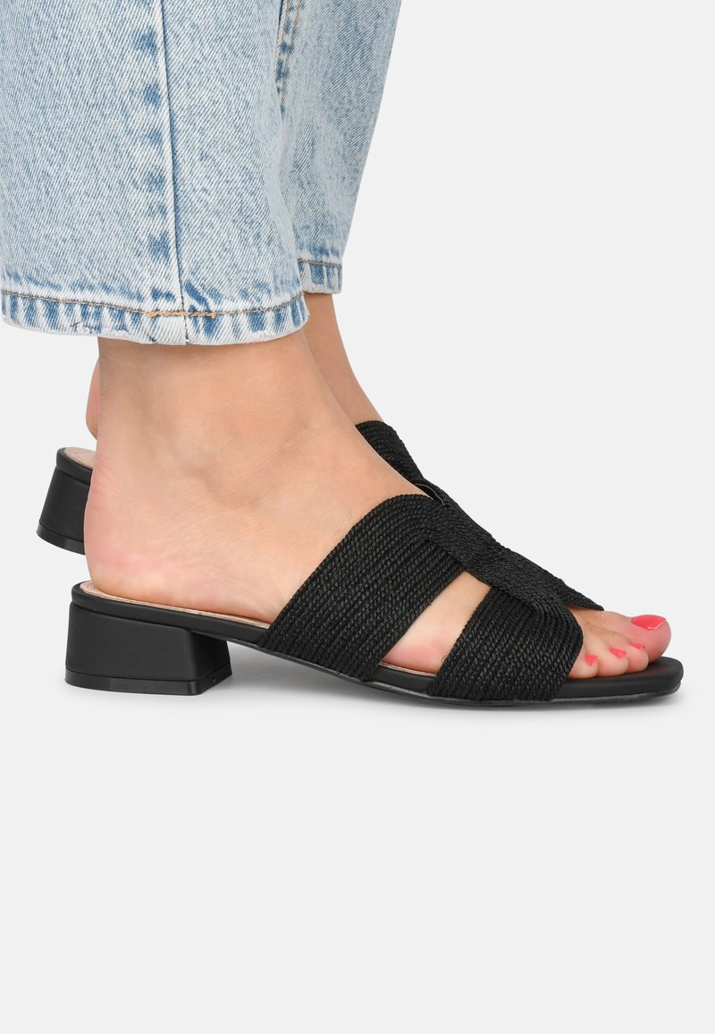 Sandales à glissière tissées noires avec un petit talon bloc, présentant deux brides croisées et des semelles en cuir lisse. Fini poli et design neutre.