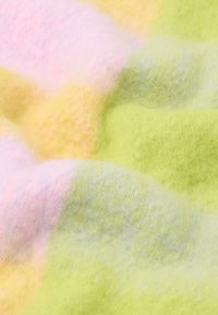 Vícebarevná deka s měkkou, nadýchanou texturou. Obsahuje pastelově růžové a žluté odstíny, které se prolínají do světlého zeleného úseku.