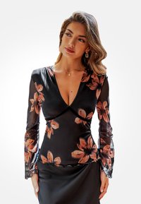 Schwarzes Blusenshirt mit langen, transparenten Ärmeln. Es hat einen tiefen V-Ausschnitt und ist mit orange- und pinkfarbenen Blumenmustern sowie einem gewellten Saum versehen.