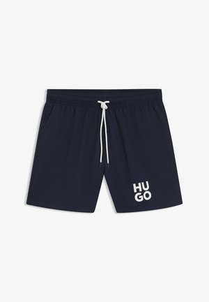 Marina simbyxor med elastisk midjeband, vit dragsko och en stor vit "HUGO"-logotyp på den nedre vänstra sidan. Slät tygtextur.