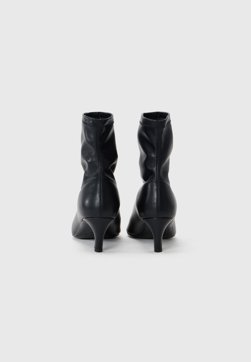 Schwarze Leder-Stiefeletten mit einem geschliffenen Design, schmalen Absätzen und genähten Details an der Oberkante. Glatte Textur mit einem eleganten Finish.