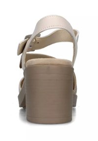 Sandali con tacco in pelle beige, dotati di una fascia larga e fibbia alla caviglia, caratterizzati da un tacco spesso e testurizzato e un soletta morbida.