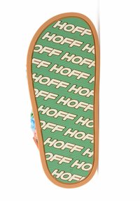 Suela de zapato en verde con patrón repetido en blanco de "HOFF"; suela de goma naranja; superficie texturizada; colores vibrantes en los bordes circundantes.