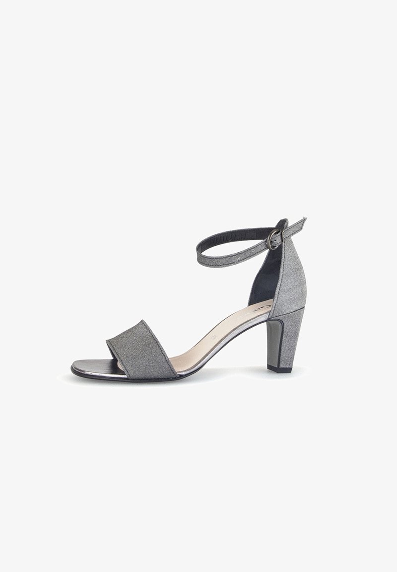 Sandale grise à talon avec une finition texturée, bout ouvert et bride de cheville. Elle présente un talon bloc pour la stabilité et des éléments de design minimalistes.
