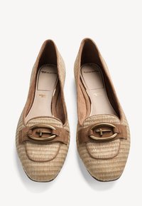 Mocassins en tissu tissé beige avec un bout arrondi, des accents en suède et une boucle ovale dorée. La doublure intérieure douce offre un confort optimal.