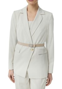 Light beige tailored blazer made of smooth fabric, featuring a single button, notched lapels, and a matching belt with a metal accent.