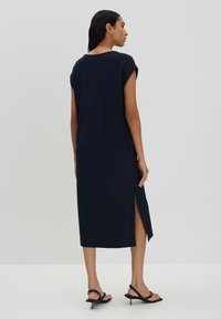 Marineblaue Midi-Kleid mit kurzen Ärmeln, seitlichem Schlitz und lockerem Schnitt. Hergestellt aus glattem Stoff, mit rundem Ausschnitt und schlichtem Design.