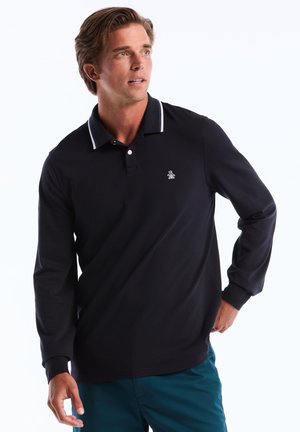 Marineblauwe polo met lange mouwen en witte kraagstrepen, voorzien van een klein logo op de borst en een klassieke pasvorm. Gemaakt van een soepele, lichte stof.
