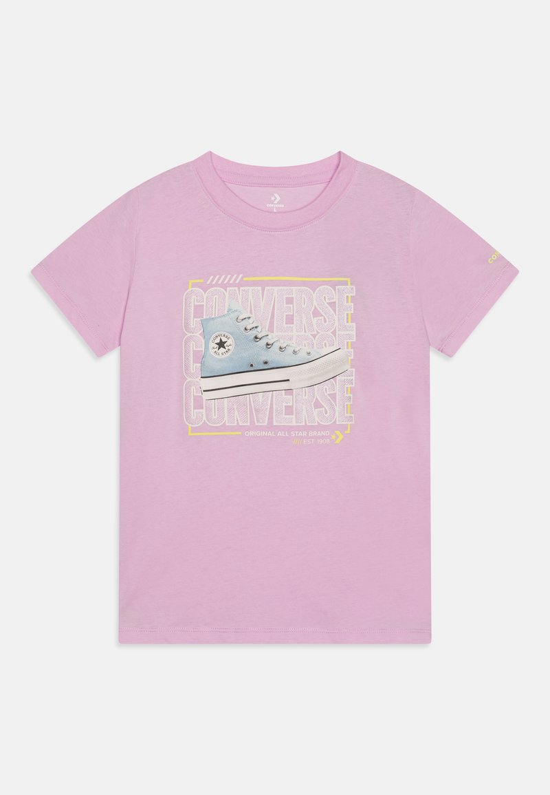 T-shirt en coton rose avec un graphique d'une chaussure Converse bleue, avec un texte "CONVERSE" en jaune vif et un accent de logo vintage.