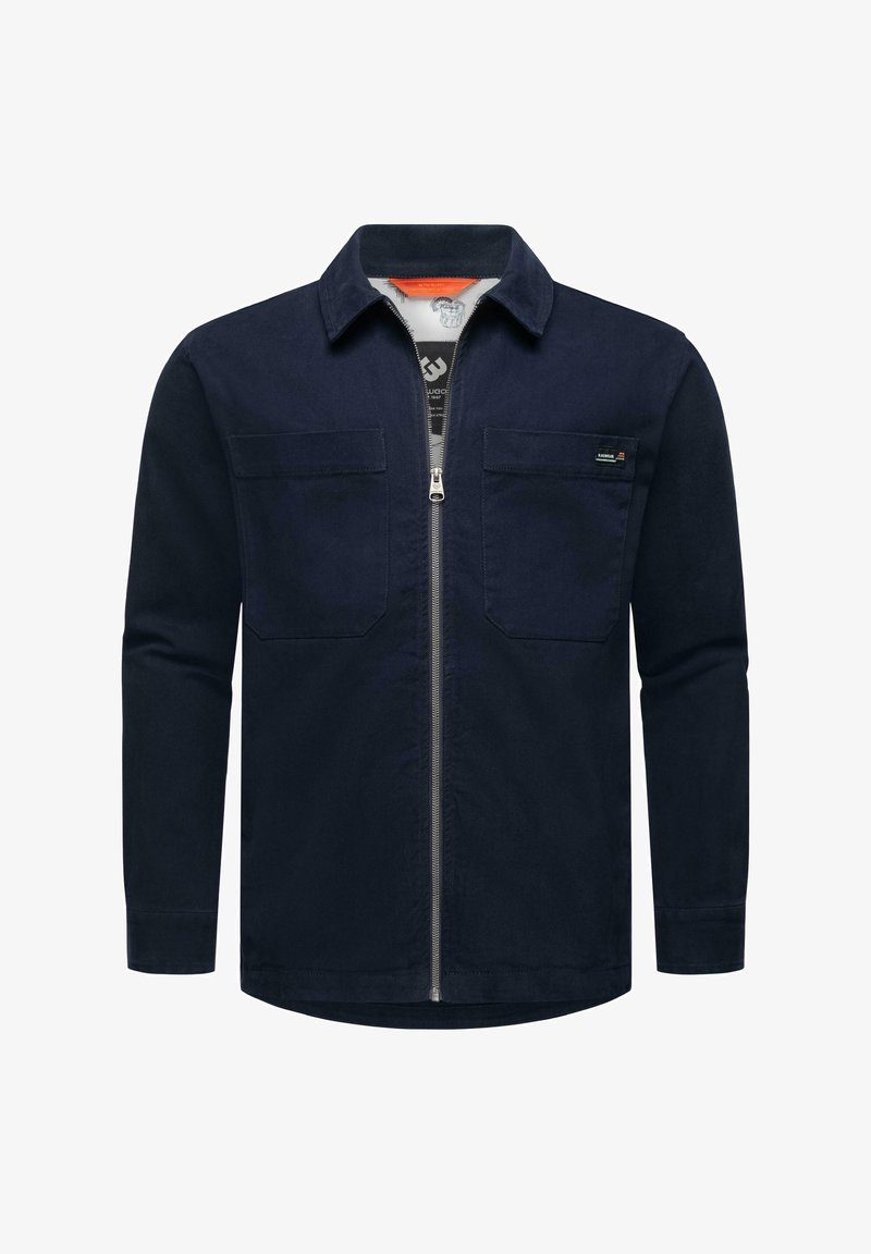 Chaqueta azul oscura con cremallera frontal y dos bolsillos en el pecho, elaborada con una tela resistente y de textura suave.