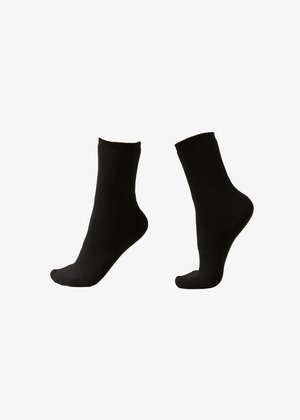 Par de calcetines negros lisos de caña mostrados en maniquíes de pie, mostrando vistas frontal y lateral sobre un fondo blanco.