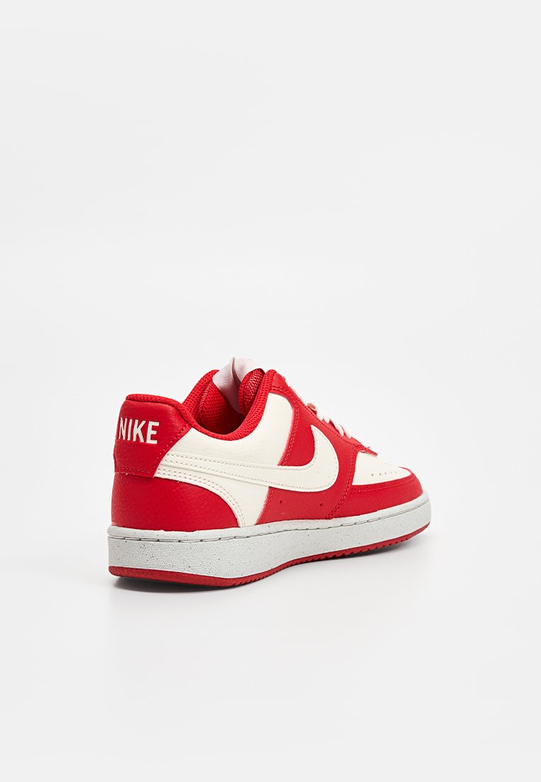 Basket rouge et blanche de Nike avec une tige en cuir lisse, un col rembourré et une semelle en caoutchouc texturé. Présente un logo swoosh distinctif et des lacets.