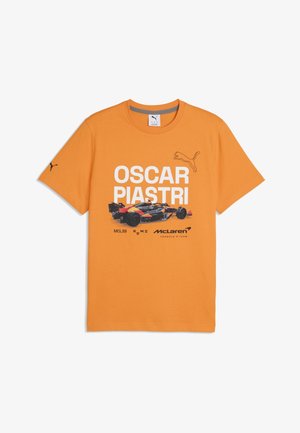 Orange short-sleeve T-shirt with white text "Oscar Piastri," a racing car graphic, Puma and McLaren logos on the chest and sleeve.