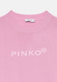 Rosa strikkegenser med rund hals, ribbestrikkede mansjetter og en brodert "PINKO up" logo i hvitt på brystet.