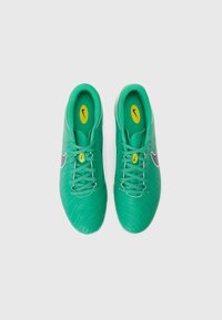 Green football shoes with textured synthetic upper, white Nike logo on the side, and yellow insoles. Features traditional lace-up design.