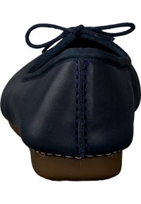Ballerines en cuir bleu marine avec un bout arrondi, des coutures ton sur ton et un petit nœud à l'avant. La semelle est marron et légèrement flexible.