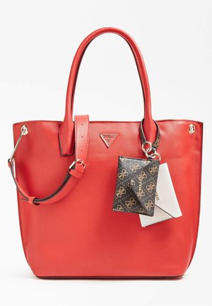 Punainen nahkainen kassi, jossa on kaksinkertaiset kahvat ja säädettävä olkahihna, etuosassa pieni musta-valkoinen kuvioitu pussukka.