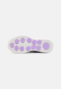 Shoe sole features a white base with purple circular traction pads, textured surfaces, and a smooth, slightly curved design.