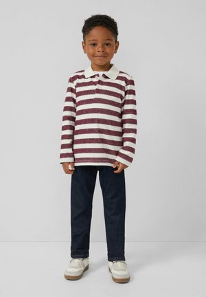 Lange mouw polo met bordeauxrode en witte strepen, kraag, drie knoopsluitingen; gecombineerd met donkere spijkerbroek en witte sneakers.